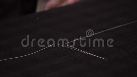 一个裁缝在把布料切成小块之前在布料上做最后的记号视频的预览图
