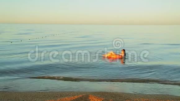 布鲁内特女士穿着泳衣在海边的游泳圈游泳视频的预览图