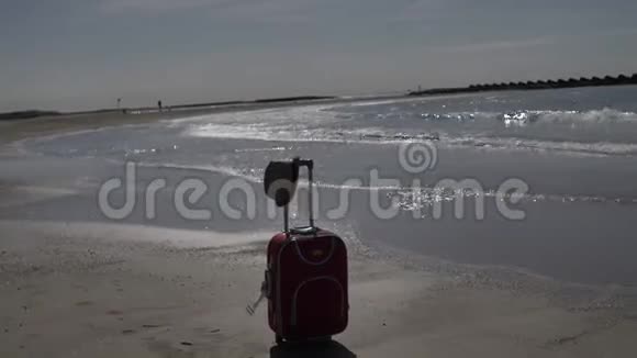 手提箱站在海边旅行概念复制空间视频的预览图