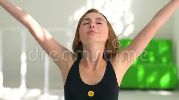 一个红发白种人女孩练习瑜伽的肖像女孩把手掌放在一起放松健康的生活方式视频的预览图