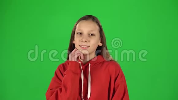 穿着红色夹克的快乐女孩在绿色屏幕上嬉戏的肖像视频的预览图