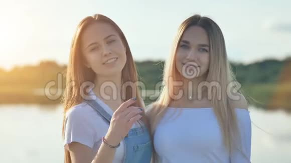 日落时分两个金发女郎在镜头前摆姿势视频的预览图