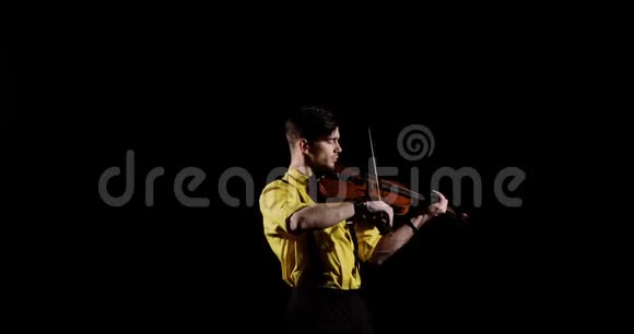 男职业小提琴手在黑色背景下演奏ALT或小提琴正面观看视频的预览图