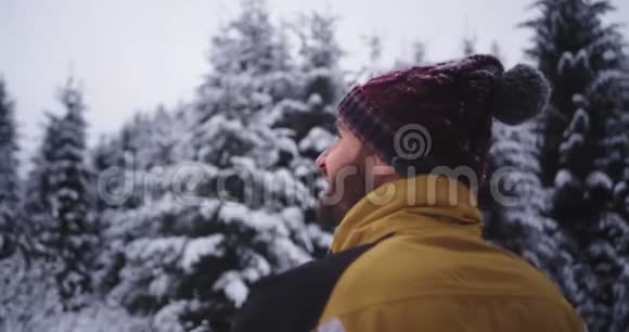 在寒冷的冬日里迷人的游客在雪林中欣赏着令人惊叹的景色微笑着他非常兴奋视频的预览图