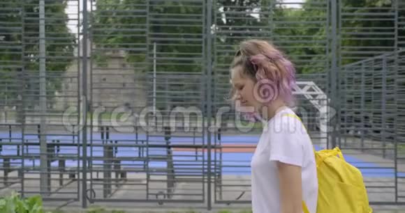 少女15岁的学生走在街头篮球场附近视频的预览图