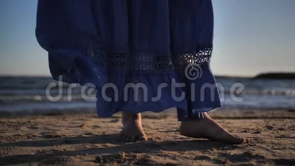 夕阳西下女人裙在海岸的风中发展慢动作视频的预览图