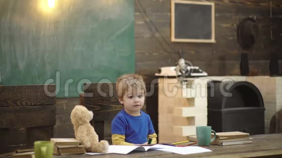 回学校去喜笑颜开的瞳在书桌前画画教室里的孩子背景是黑板泰迪视频的预览图