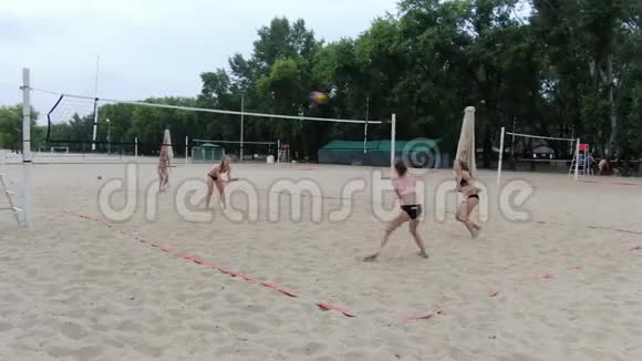 沙滩上激烈的排球比赛女人们都在跳着去拿球视频的预览图