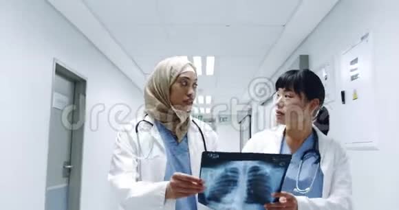 两名女医生拿着4kX光在走廊散步视频的预览图
