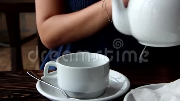 女孩用杯子倒茶视频的预览图