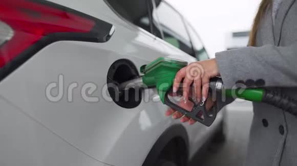 在加油站的一个特写镜头里女人往她的车里灌汽油慢动作视频的预览图