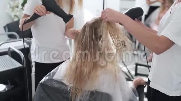 关闭理发室干女人湿发吹风机后染发视频的预览图