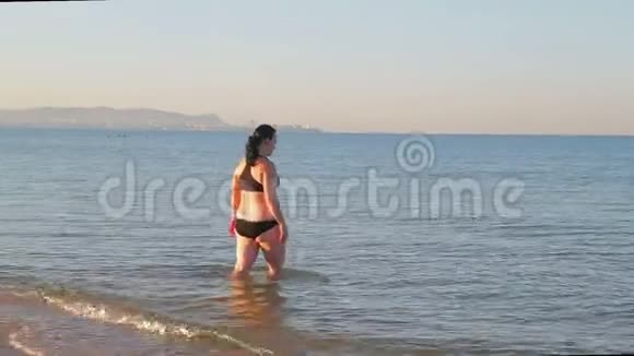一个穿着运动泳衣的黑发女人在做瑜伽后去海里游泳视频的预览图