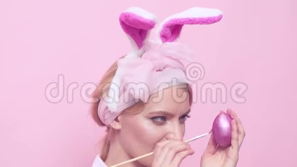 把蛋画得紧紧的可爱的穿兔子服装的复古女人带着复活节彩蛋的兔子耳朵里的快乐女人有趣的复活节视频的预览图