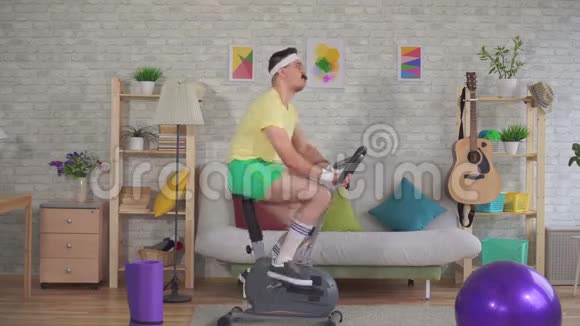 一个80的年轻有趣的运动健将带着胡子骑着一辆运动自行车竖起大拇指视频的预览图