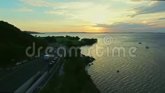 日落时道路及湖泊河流的鸟瞰图视频的预览图
