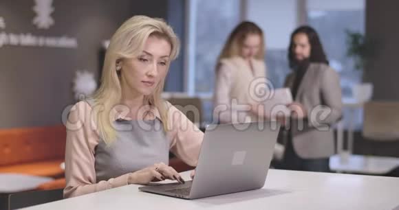年轻漂亮的高加索女人在笔记本电脑键盘上打字的肖像自信成功的CEO在工作场所的肖像视频的预览图
