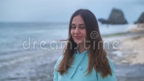 肖像时髦的女人是一个专业摄影师与相机她在暮色中拍摄海洋背景照片4k视频的预览图