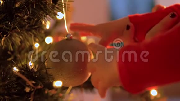 婴儿手触摸球挂在圣诞树上视频的预览图