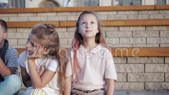 可爱的小孩子坐在长凳上快乐的童年视频的预览图