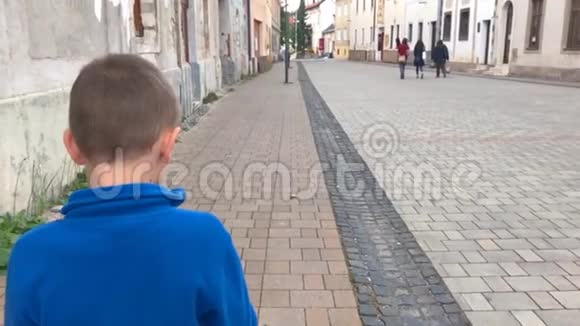 跟着悲伤的小男孩在城市里缓慢地走着视频的预览图