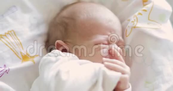 哭哭啼啼的新生儿的画像双手合嘴脸特写视频的预览图