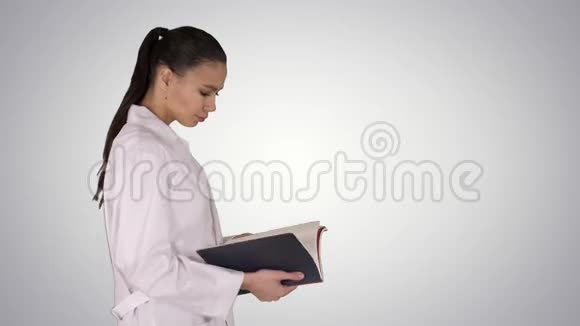 有吸引力的医学学生或医生与笔记本步行和阅读梯度背景视频的预览图