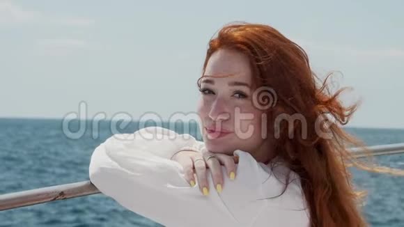 一个红头发的女孩看着你微笑一阵海风在吹她的头发视频的预览图