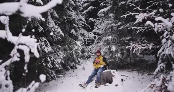 一个英俊的男子独自在雪林中旅行他想取暖停下来休息一下视频的预览图
