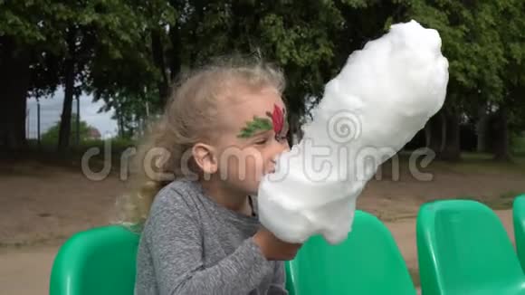 可爱的4岁女孩的肖像金发吃甜的白色棉花糖万向节视频的预览图
