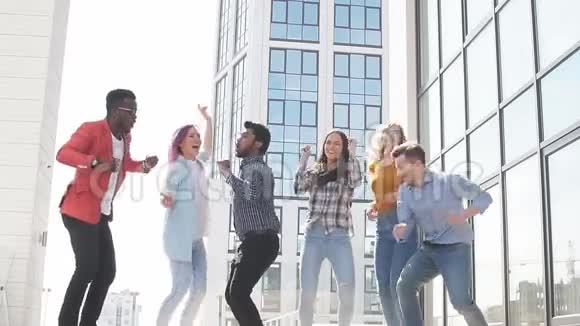 多种族的年轻商人通过跳舞和跳楼来庆祝成功的交易视频的预览图