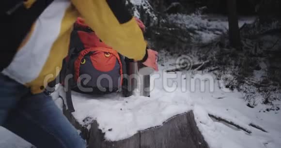 一位年轻游客在雪地森林中举着一个铁杯的特写细节他欣赏风景和感受视频的预览图