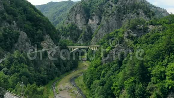 罗马尼亚喀尔巴阡山脉中连接山路的拱形桥的鸟瞰图视频的预览图