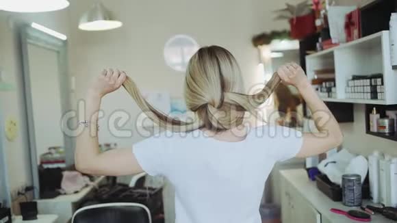 美丽的淡色女人在美容院从背后露出头发视频的预览图