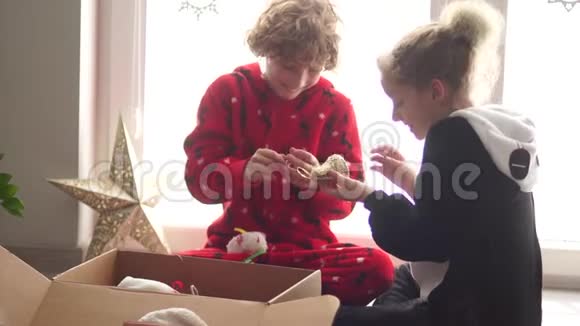 孩子们穿着睡衣打开圣诞玩具新年球圣诞准备平安夜幸福的家庭视频的预览图