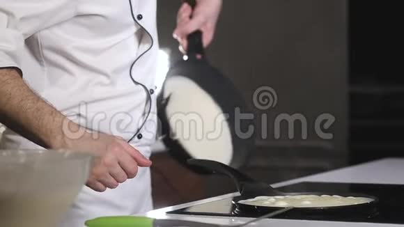 煮煎饼的过程男厨师在热锅里准备煎饼视频的预览图