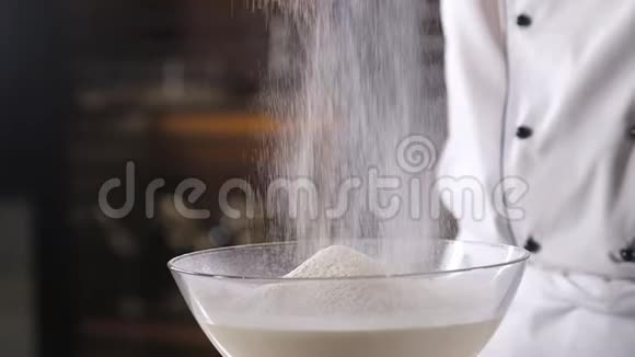 厨房里的厨师把小麦粉倒入金属过滤器中然后把面粉筛出来视频的预览图