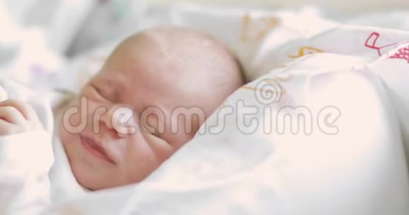 一个刚出生的婴儿在睡梦中闭着眼睛哭泣的肖像面部特写视频的预览图