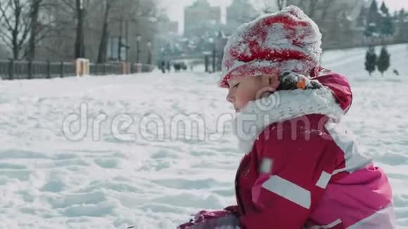 少女在冬季公园里撒雪冬天玩雪的女孩视频的预览图