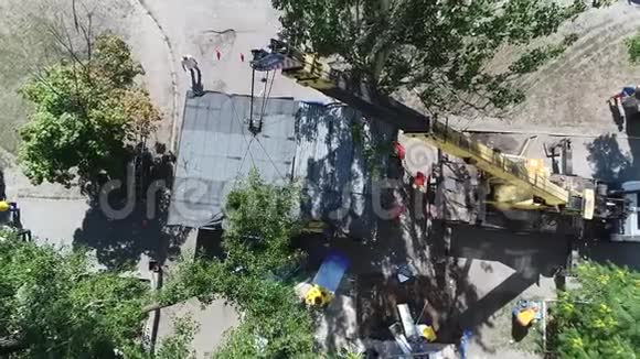 城市采用挖掘机进行鸟瞰拆除房屋挖掘机装载卡车视频的预览图