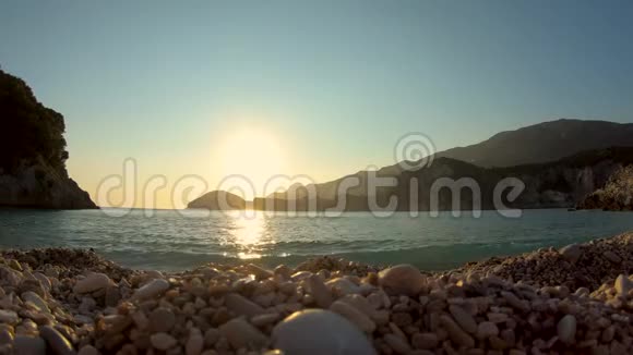 在小浪淘沙的卵石沙滩上看日落视频的预览图