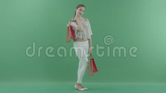 性感的女人拿着袋子站在绿色的屏幕上取笑某人视频的预览图