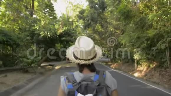 亚洲女性徒步旅行者带背包穿越热带雨林后景视频的预览图