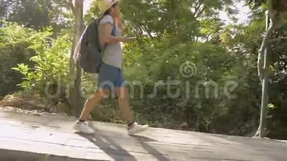 女徒步旅行者背着背包穿过热带雨林视频的预览图