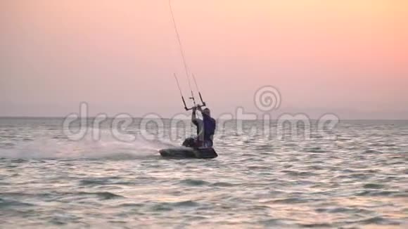 埃及赤鸢在海上冲浪一个人在背景上随着太阳飞翔视频的预览图
