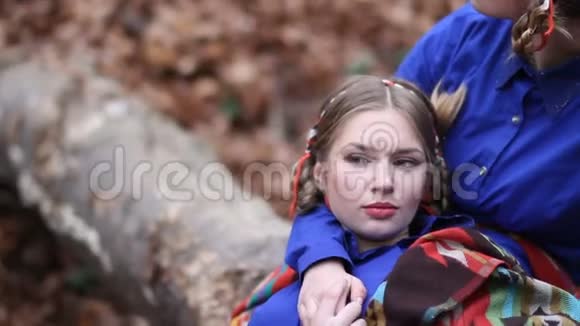 两个双胞胎女孩在秋天的森林里休息视频的预览图