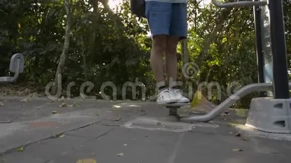 亚洲女人带着背包玩运动设备在公共公园里使用手机视频的预览图