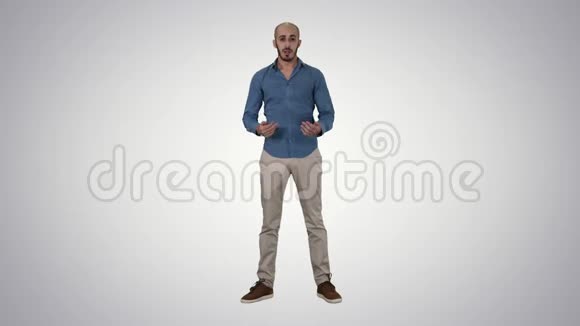 穿着衬衫的阿拉伯年轻人说话呈现一些东西并指向梯度背景上的侧面视频的预览图