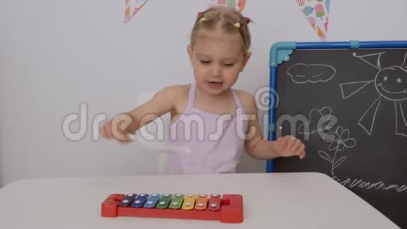一个小女孩坐在孩子们房间桌子旁玩木琴视频的预览图