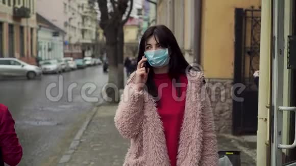 女人走在街上通过电话说话Covid病毒流行19视频的预览图